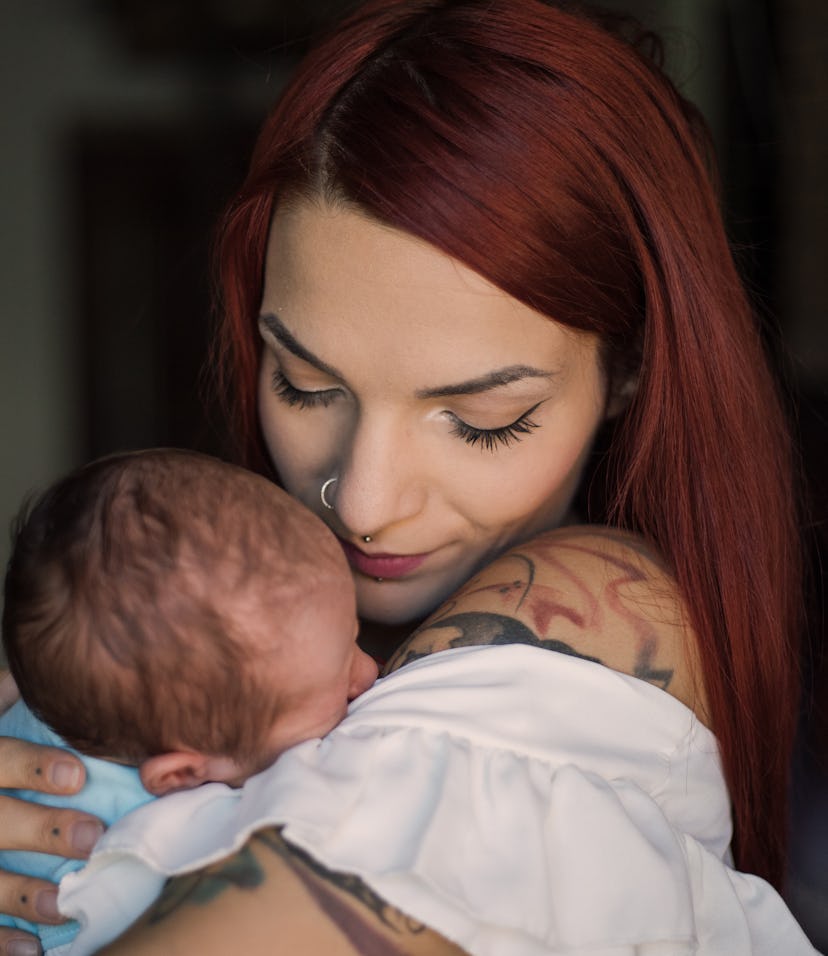 mom with tattoos holding her newborn