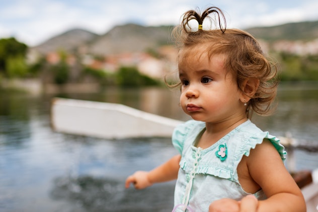 Young happy baby girl enjoying boat ride on a river.