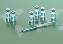 Digital generated image of COVID-19 vaccine bottles and syringe on green surface with world map.