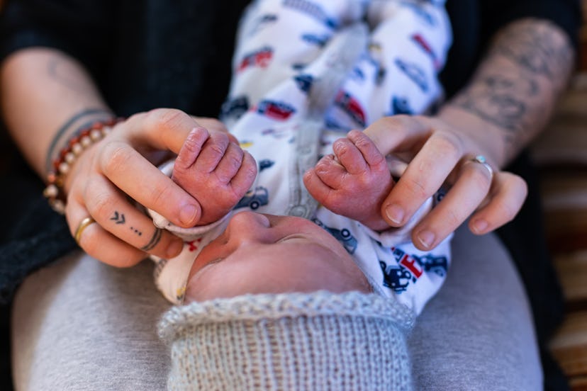 tattooed woman holding baby on lap