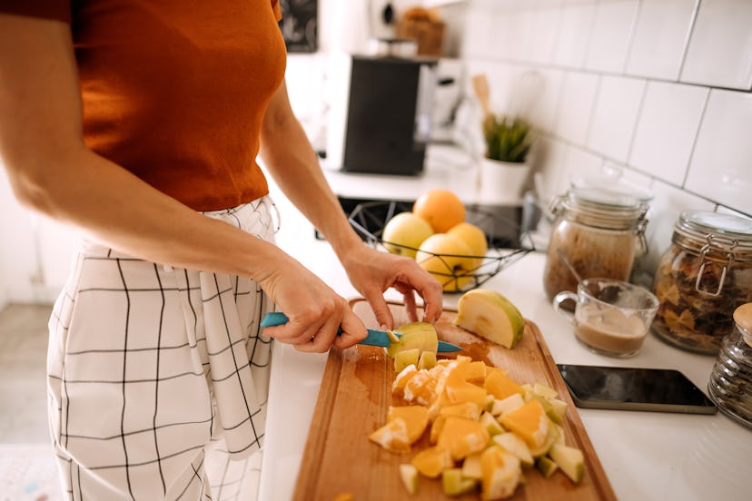Young woman preparing fruits for healthy meal
