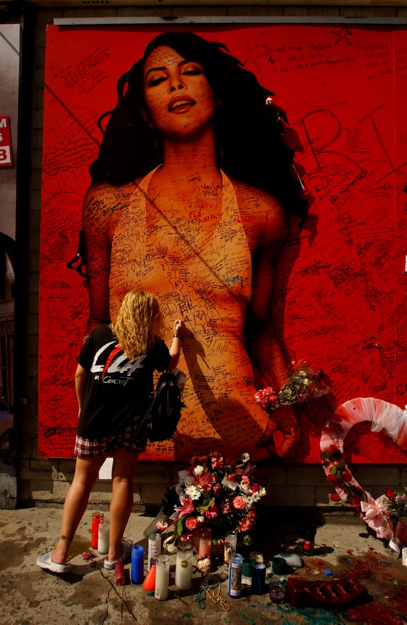 A fan writes a message on a billboard of the late singer and actress Aaliyah August 28, 2001 on Suns...