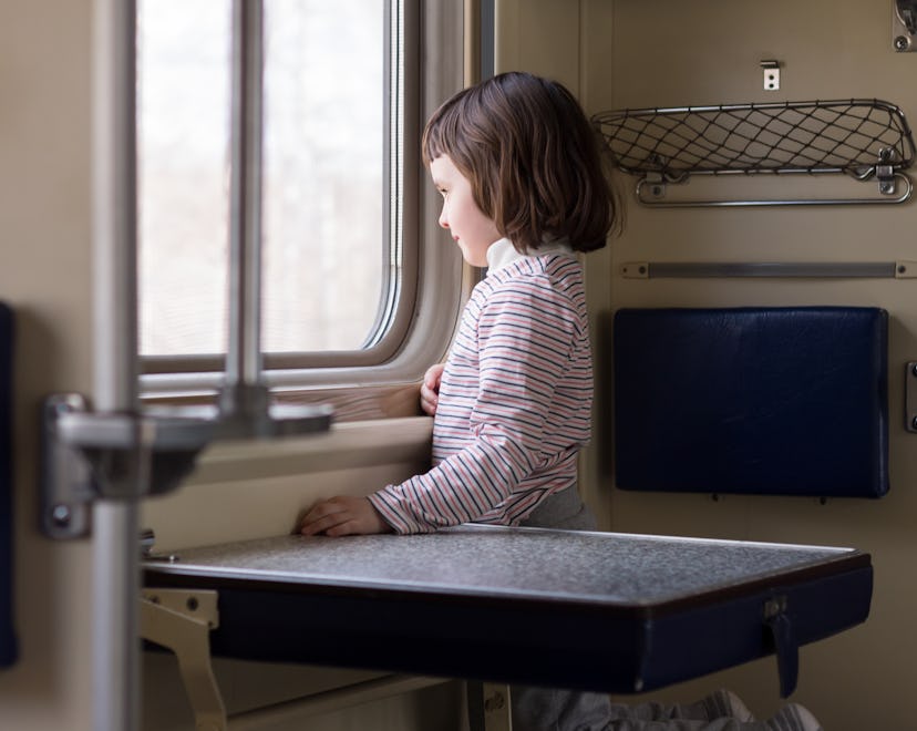 child travels on a second class train and looks out the window