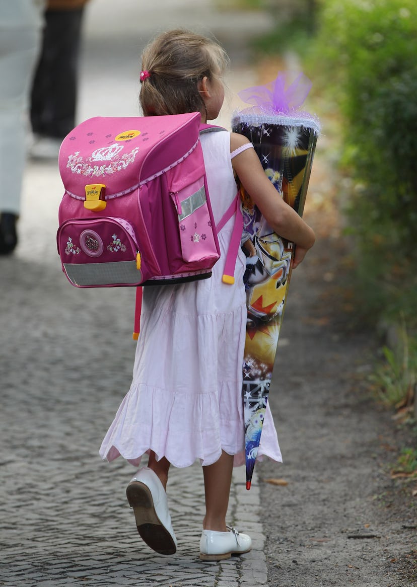 A child holding a "Schultuete," a conical container filled with sweets and treats. The first-day-of-...