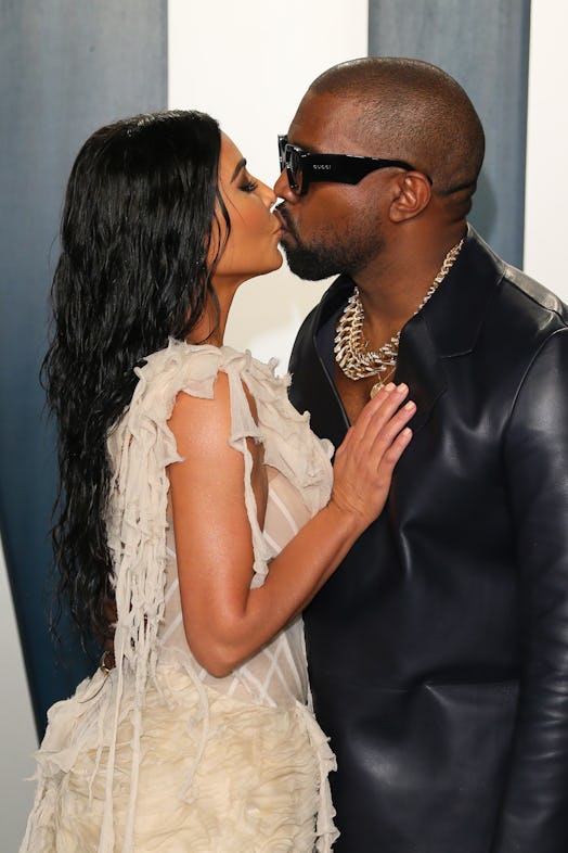 West and Kardashian kiss each other at a red carpet event. 