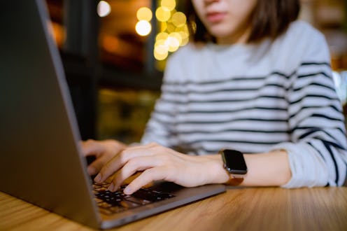 Serious Asian woman concentrate with her work while sitting at restaurant at night.