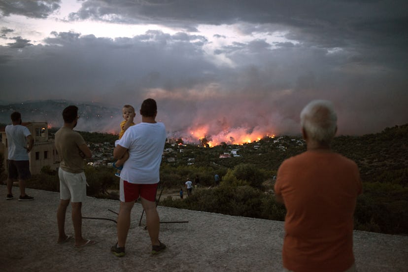  People watch a wildfire in the town of Rafina, near Athens, on July 23, 2018