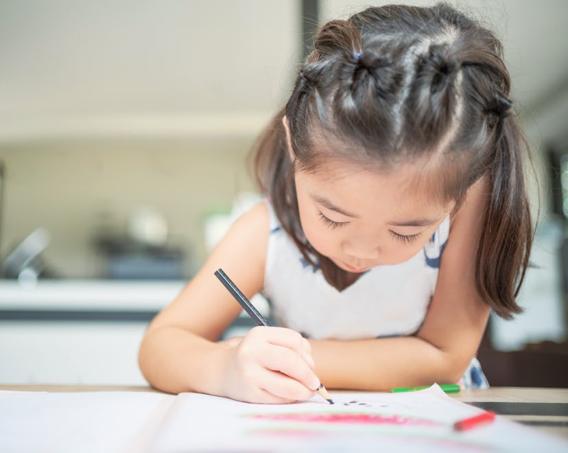 Young girl coloring with colored pencil