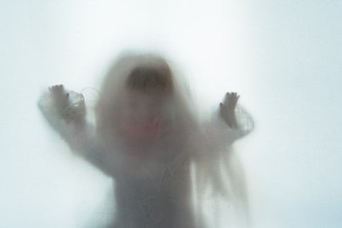 A scary edit of an old doll holding its hands up, shot through a semi transparent material. Creating...