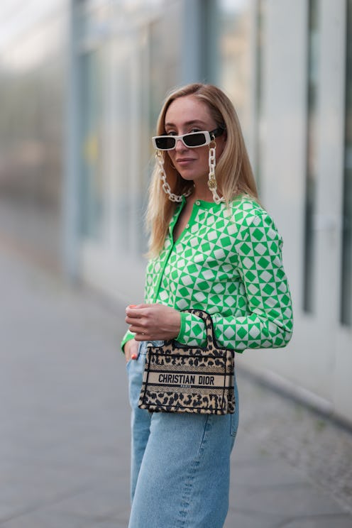 BERLIN, GERMANY - AUGUST 03: Sonia Lyson wearing Dior mini bag, green and white Zara cardigan, & oth...