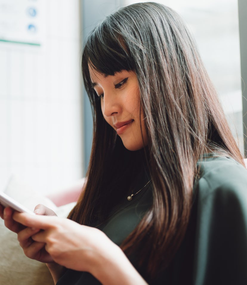 Asian beautiful woman using smartphone in a cafe.