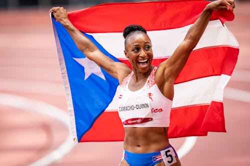 Jasmine Camacho-Quinn poses with the Puerto Rican flag after competing in the Women's 100m Hurdles F...
