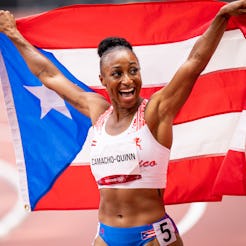 Jasmine Camacho-Quinn poses with the Puerto Rican flag after competing in the Women's 100m Hurdles F...