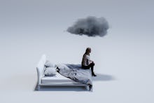 Computer graphic of sad mid adult woman sitting on corner of double bed with dark cloud above head. ...