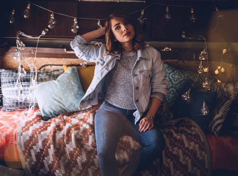 Beautiful Young Blond Woman Resting In Camper and Christmas Decorative Lights She Arranged