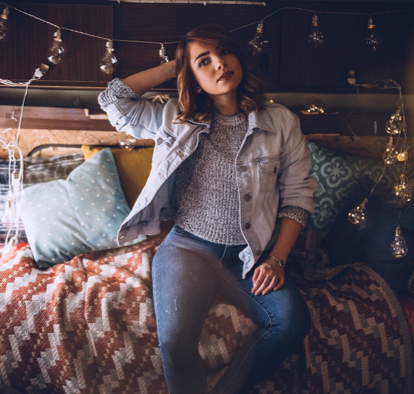 Beautiful Young Blond Woman Resting In Camper and Christmas Decorative Lights She Arranged