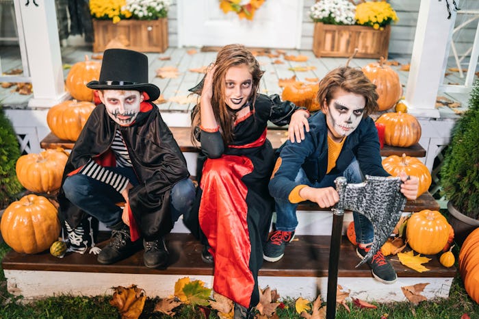 Kids dressed in Halloween costumes sitting on the stairs