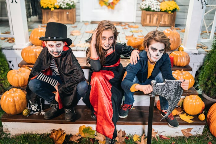 Kids dressed in Halloween costumes sitting on the stairs 