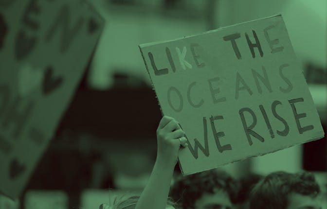 Climate activists hold a placard reading "Like the oceans we rise"