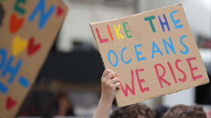 Climate activists hold a placard reading "Like the oceans we rise"