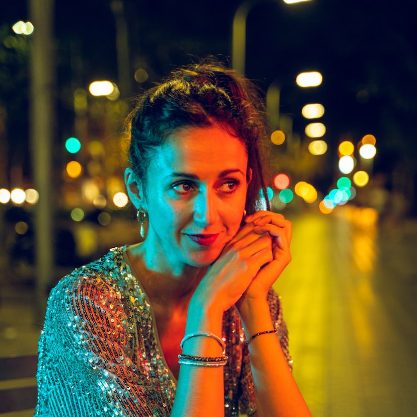 Woman going out at night wearing a glowing dress during Mercury retrograde fall 2021, which will aff...