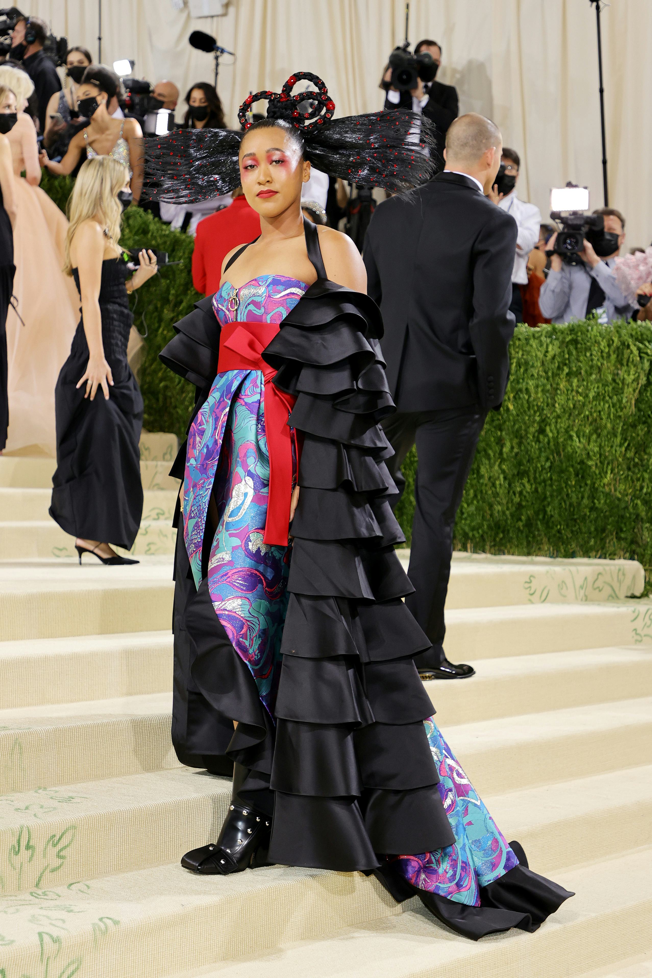 Naomi Osaka posed at the 2021 Met Gala in a colorful Louis Vuitton gown and a memorable hairstyle.