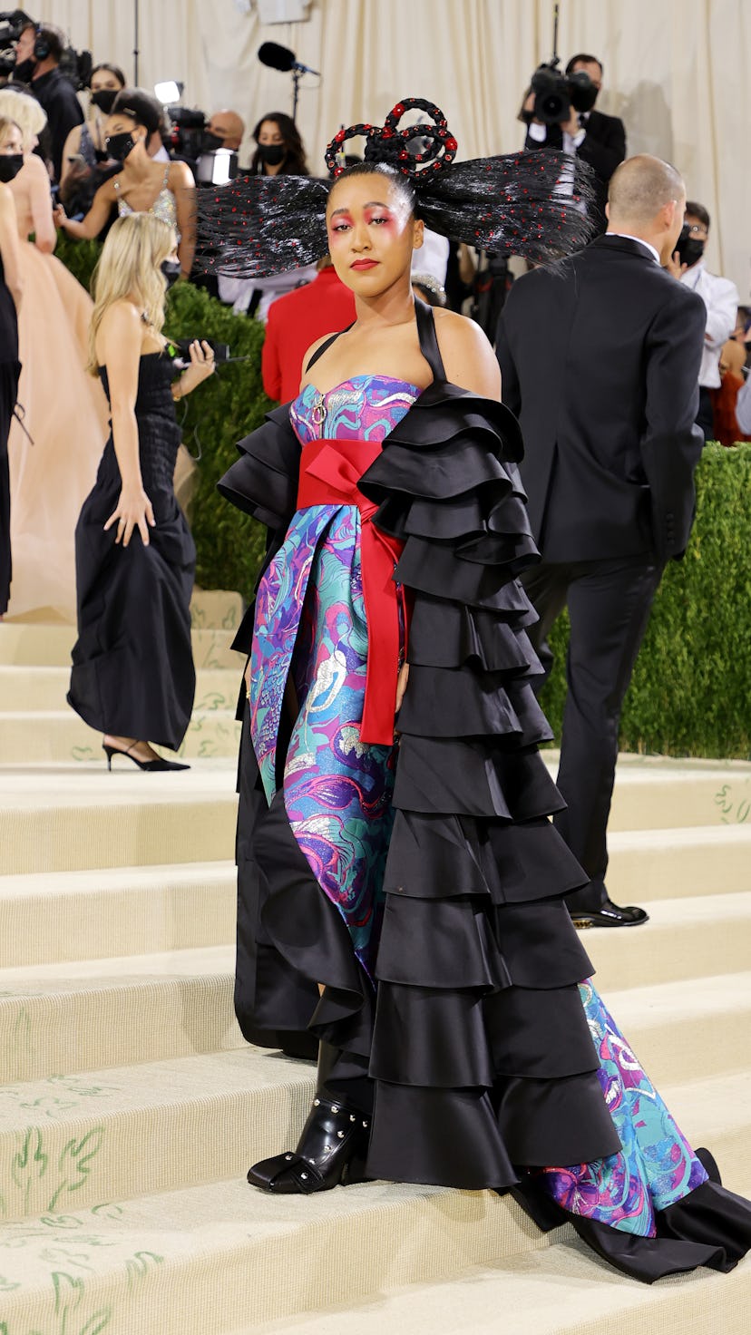 Naomi Osaka posed at the 2021 Met Gala in a colorful Louis Vuitton gown and a memorable hairstyle.
