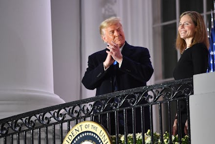 US President Donald Trump applauds Judge Amy Coney Barrett after she was sworn in as a US Supreme Co...