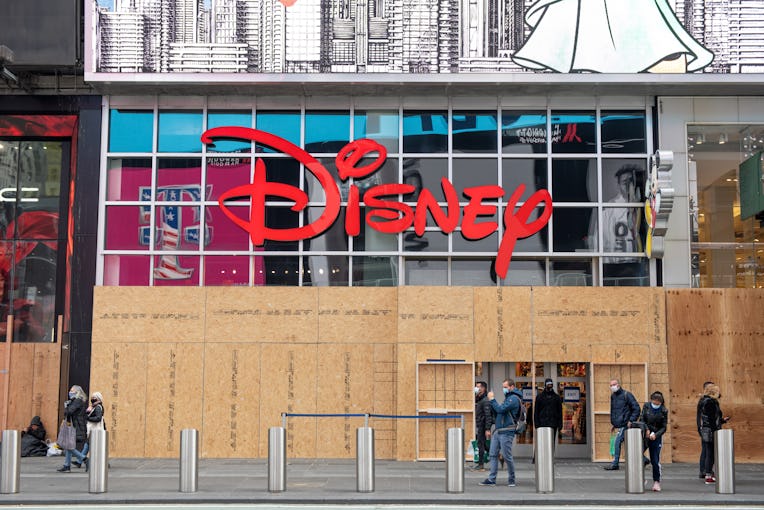 NEW YORK, NEW YORK - NOVEMBER 03: People wearing masks walk past the Disney Store in Times Square on...
