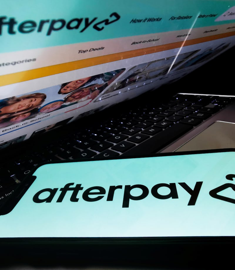 Afterpay logo displayed on a phone screen and Afterpay website displayed on a laptop screen are seen...