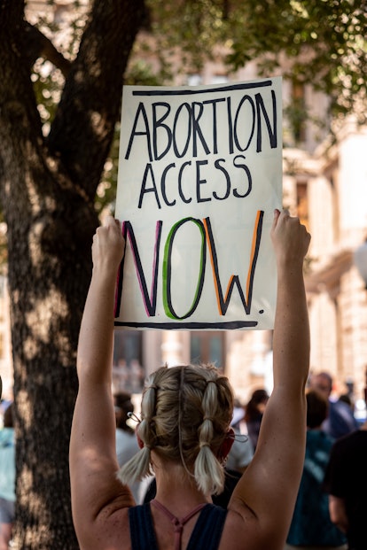 A woman carries a sign calling for access to abortion at a rally at the Texas State Capitol on Septe...