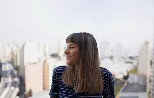 Young woman contemplating on apartment's balcony