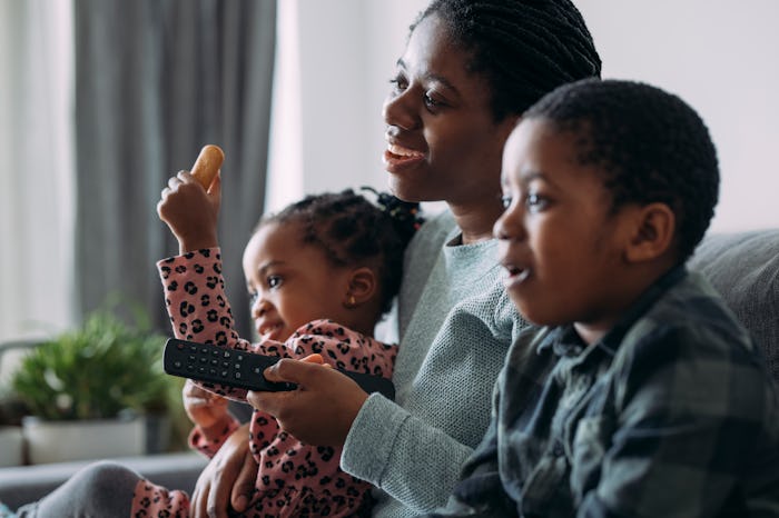 mom on the couch with her two children watching TV