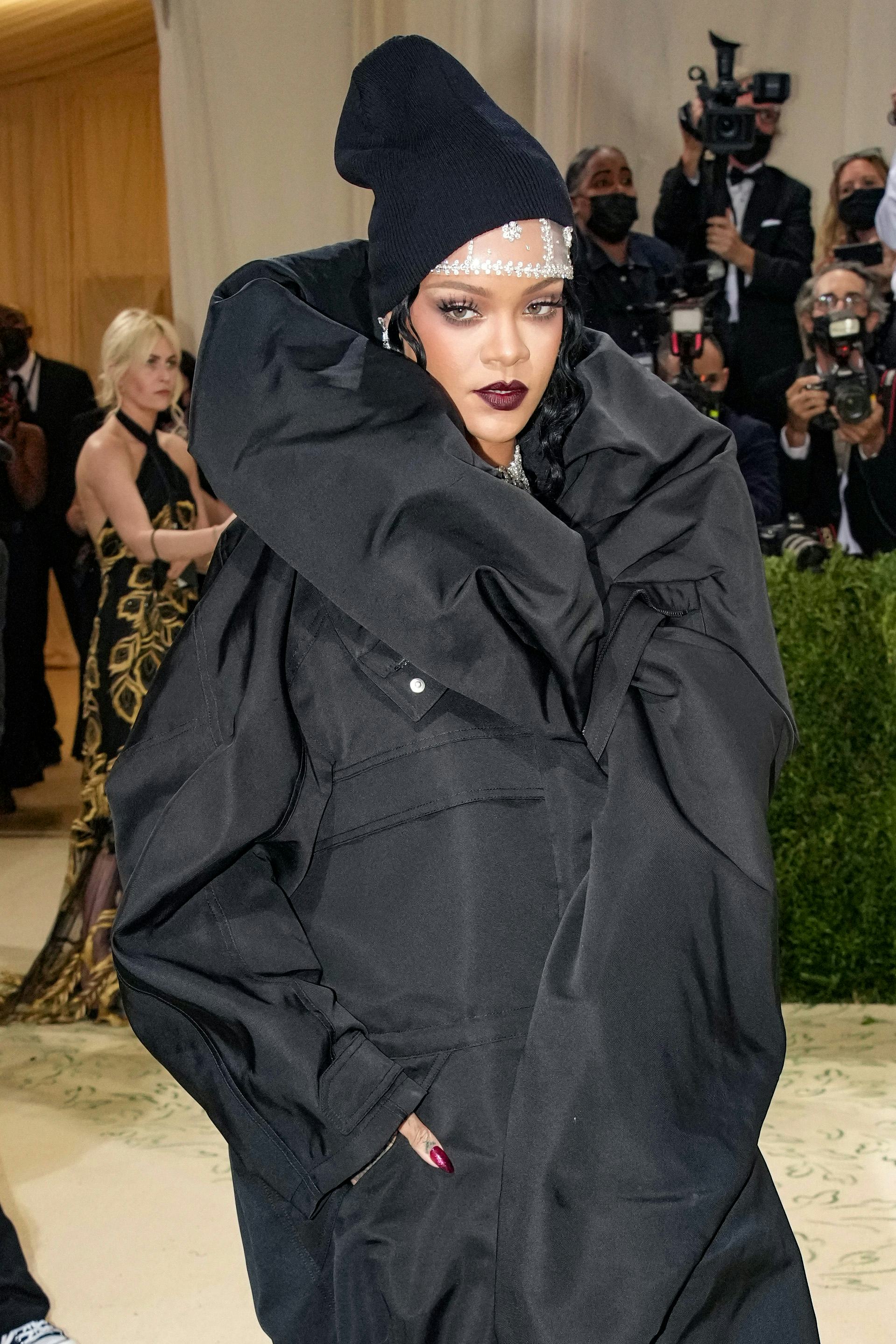 Rihanna attends the Met Gala wearing an all black jacket dress combination.