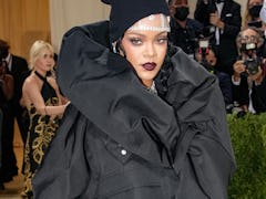 Rihanna attends the Met Gala wearing an all black jacket dress combination.
