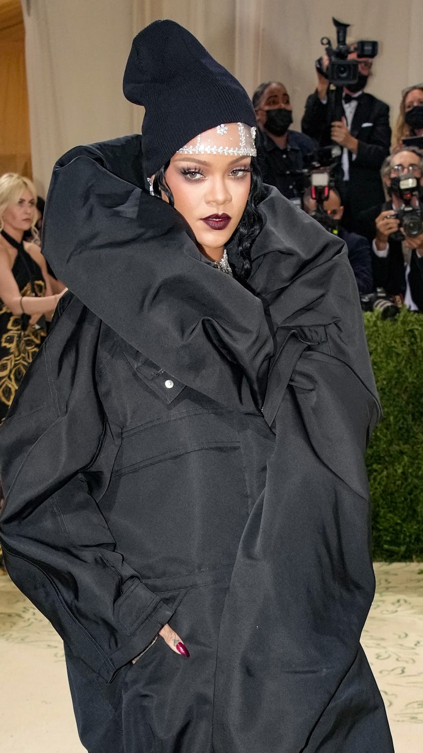 Rihanna attends the Met Gala wearing an all black jacket dress combination.