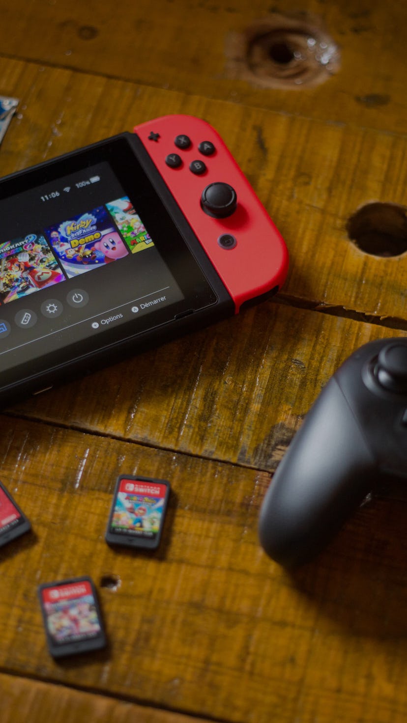 In this photo illustration, a turned on Nintendo Switch with 2 Joy-Con attached on it, a Pro Control...