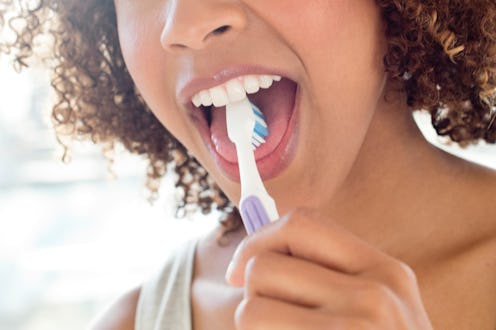 Portrait of mid adult woman brushing tongue.
