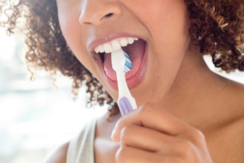 Portrait of mid adult woman brushing tongue.