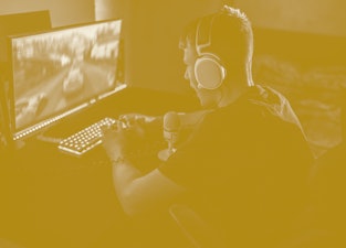 teenager boy playing video games in a dark room, wearing a white headset