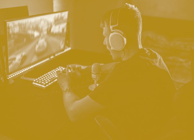 teenager boy playing video games in a dark room, wearing a white headset