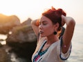 Young woman with long red hair enjoys beautiful sunset during the October 2021 new moon in Libra, wh...
