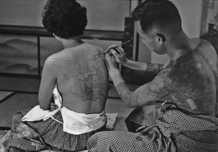 Tattoo artist Horigoro at work on a design on a woman's back in Japan in 1955. (Photo by FPG/Getty I...