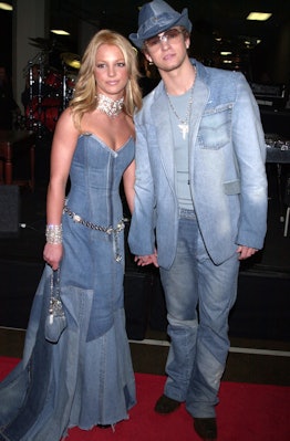 Britney Spears and Justin Timberlake holding hands in matching denim outfits.