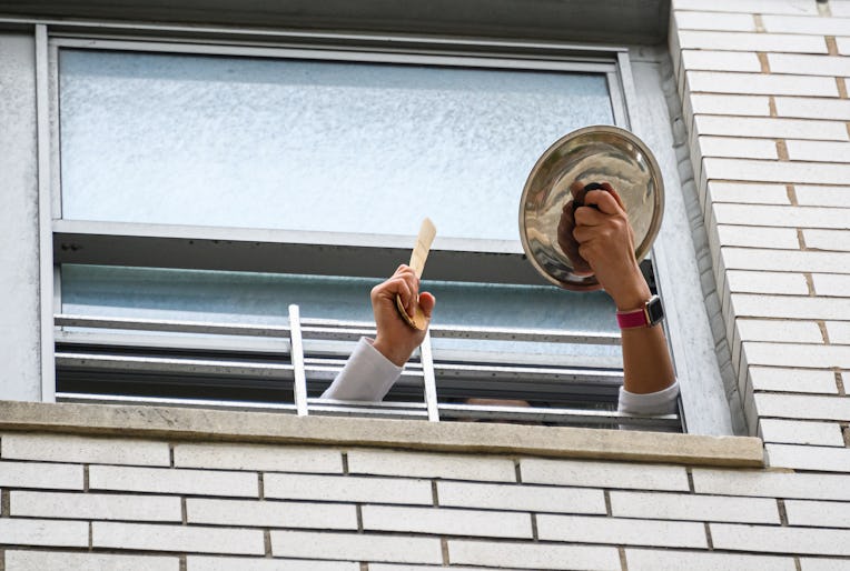 NEW YORK, NEW YORK - MAY 18: A person applauds from their window to show their gratitude to medical ...