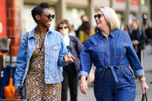 LONDON, ENGLAND - SEPTEMBER 13: A guest (L) wears sunglasses, a blue denim jacket, a floral print ju...
