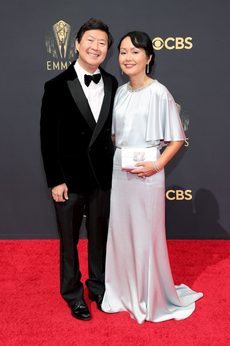 Ken Jeong in a black suit and a white shirt and Tran Jeong in a white sating dress at the Emmys Red ...