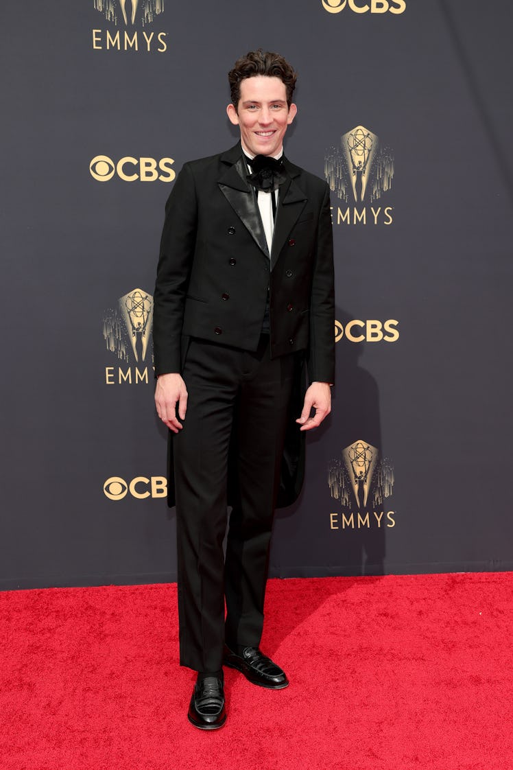 Josh O'Connor in a black suit, a white shirt and a black tie at the Emmys Red Carpet 2021
