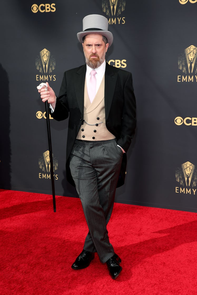 Brendan Hunt in a beige waistcoat, a white shirt, and grey pants at the Emmys Red Carpet 2021