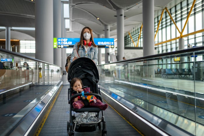 Young Woman traveling with her baby wearing a face mask during the COVID-19